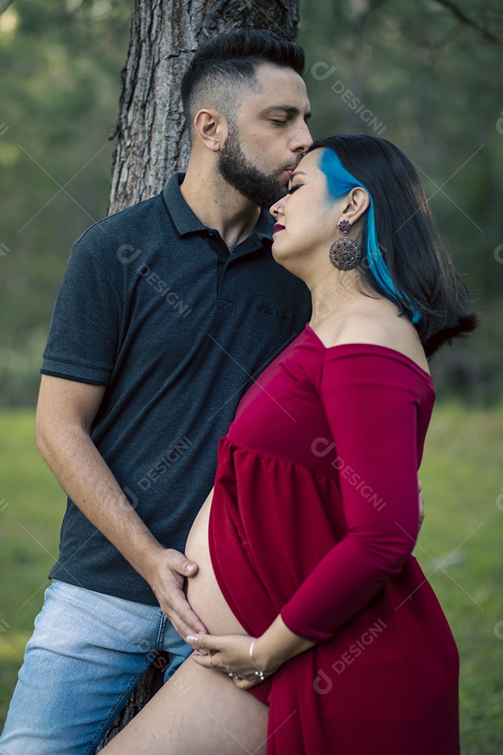 Homem com ao lado de sua esposa gravida sobre um lindo lugar paisagem