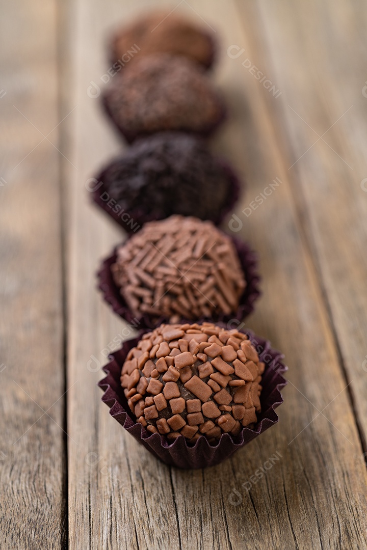 Típicos brigadeiros de chocolate brasileiros sobre mesa de madeira