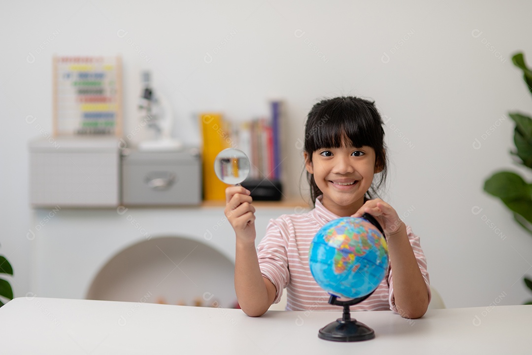 A menina asiática está aprendendo o modelo do globo