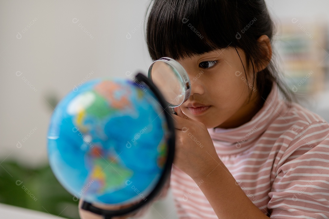 A menina asiática está aprendendo o modelo do globo