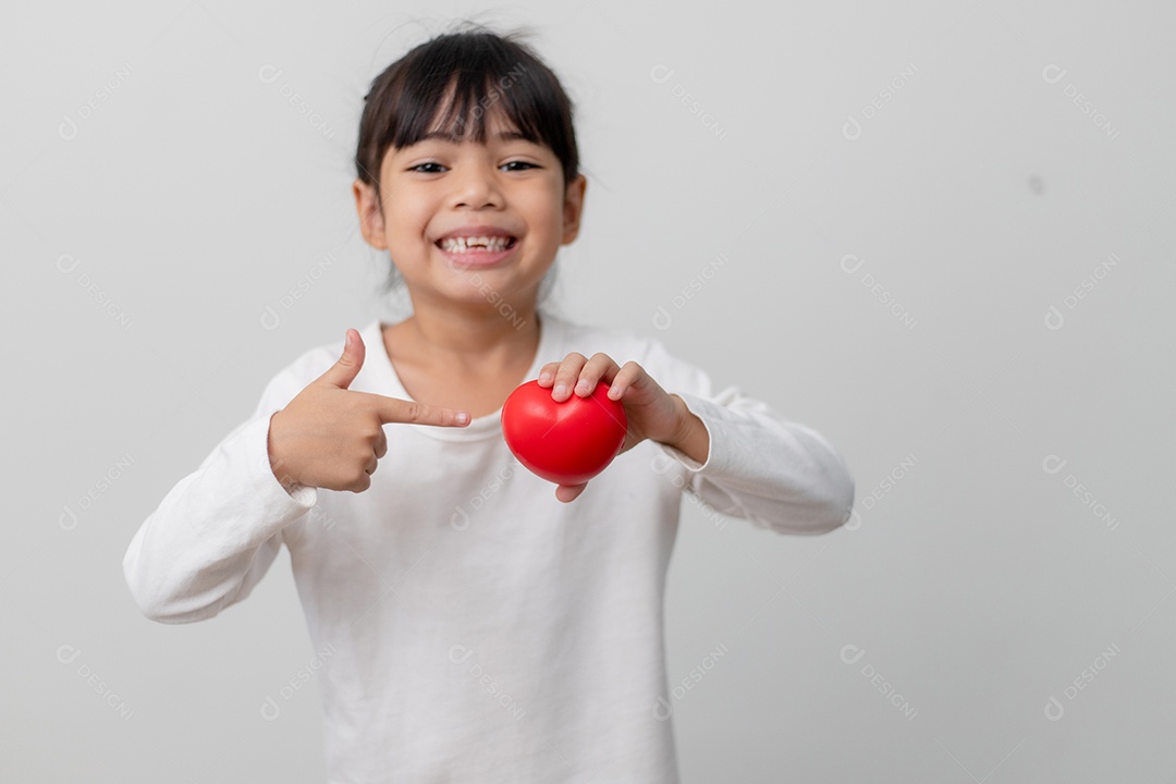 Retrato de uma garotinha asiática segurando uma placa de coração vermelho