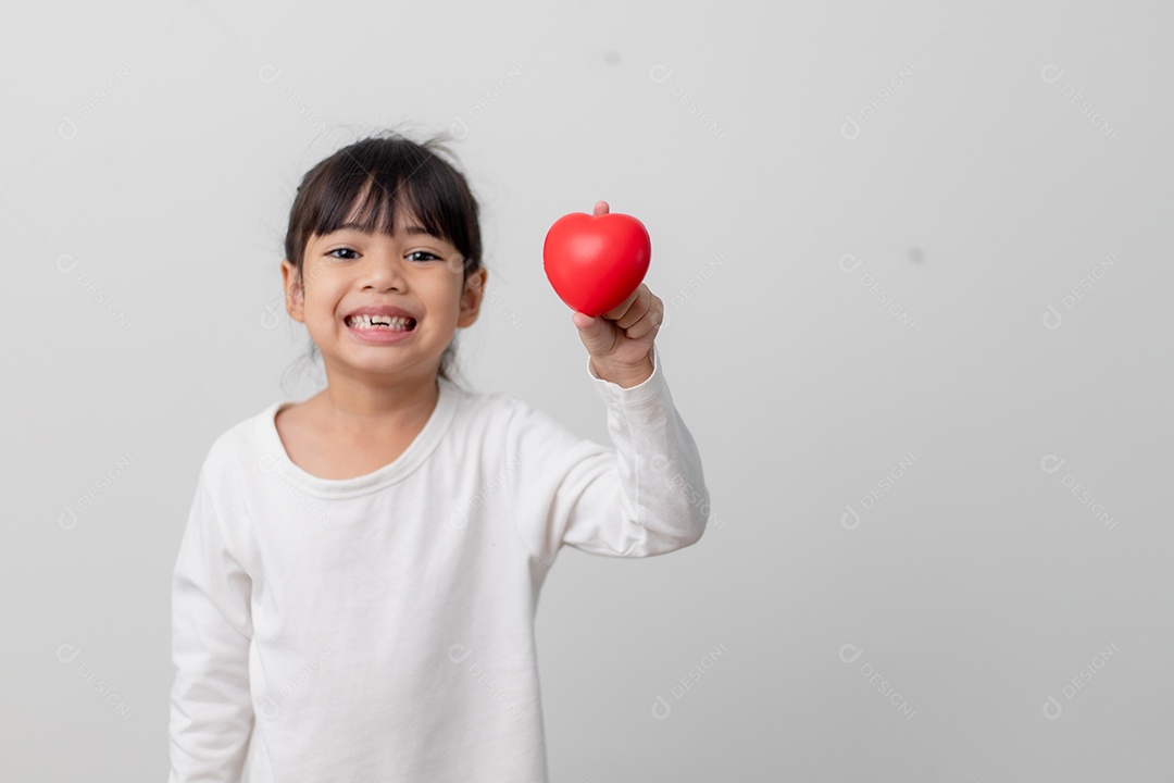 Retrato de uma garotinha asiática segurando uma placa de coração vermelho