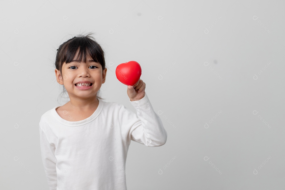 Retrato de uma garotinha asiática segurando uma placa de coração vermelho