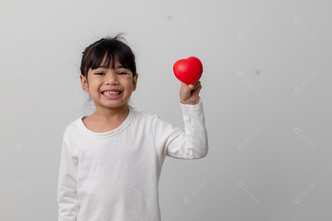 Retrato de uma garotinha asiática segurando uma placa de coração vermelho