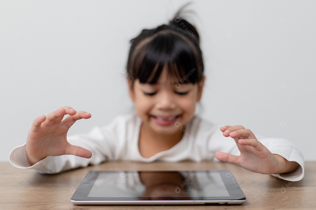 Menina bonitinha asiática tocando a tela do tablet digital