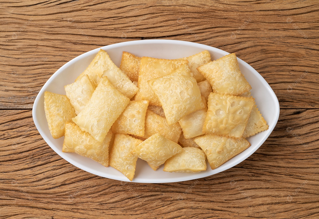 Pastel, petiscos típicos brasileiros sobre a mesa de madeira.