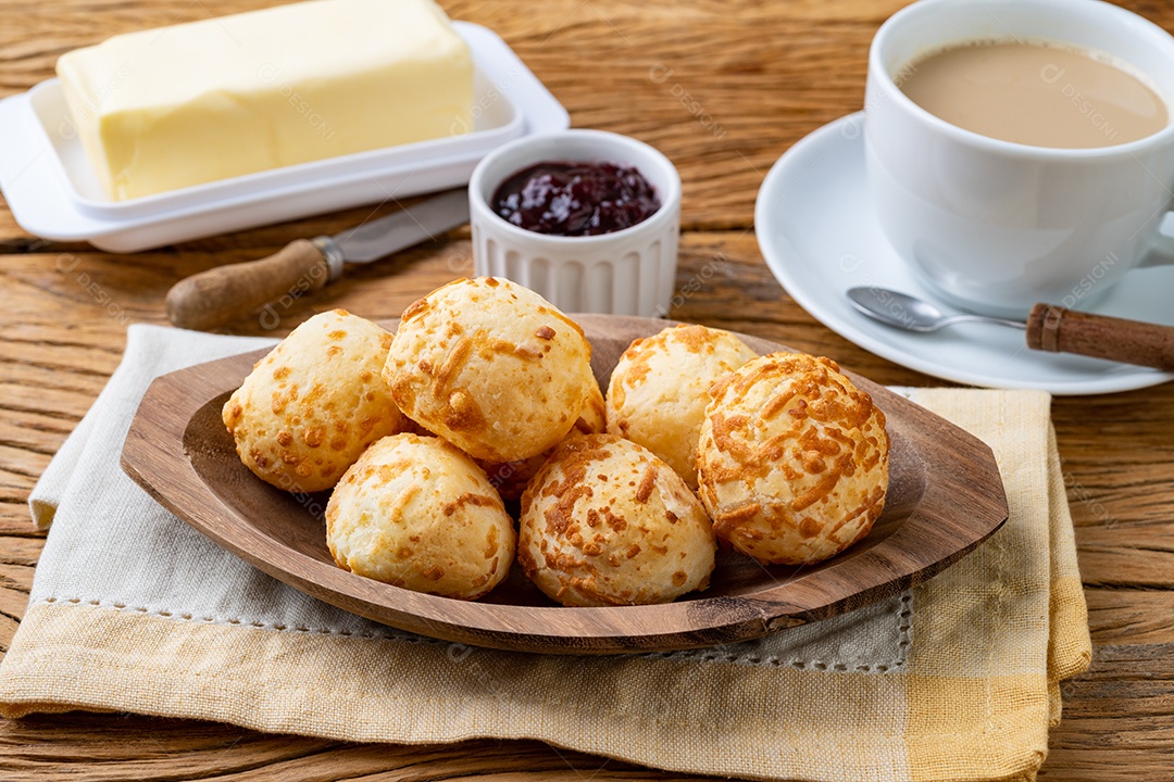 Pão de queijo brasileiro típico em um prato com café, manteiga