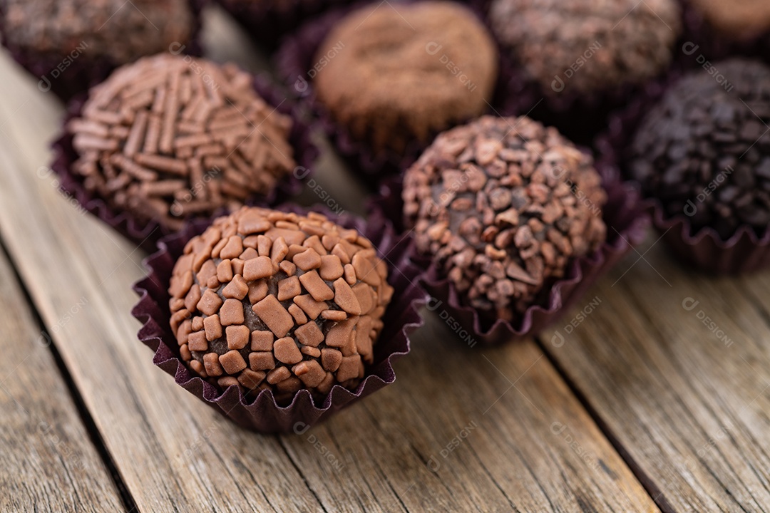 Típicos brigadeiros de chocolate brasileiros sobre mesa de madeira