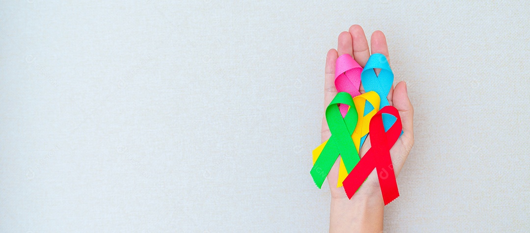 World Cancer Day February 4th Hand holding blue red green pin