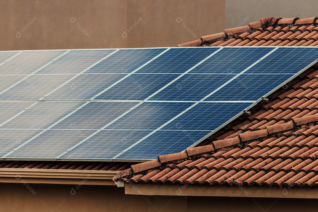 Painéis solares na casa de telhado vermelho em um dia ensolarado e nublado. Instalação de Energia Solar Fotovoltaica.