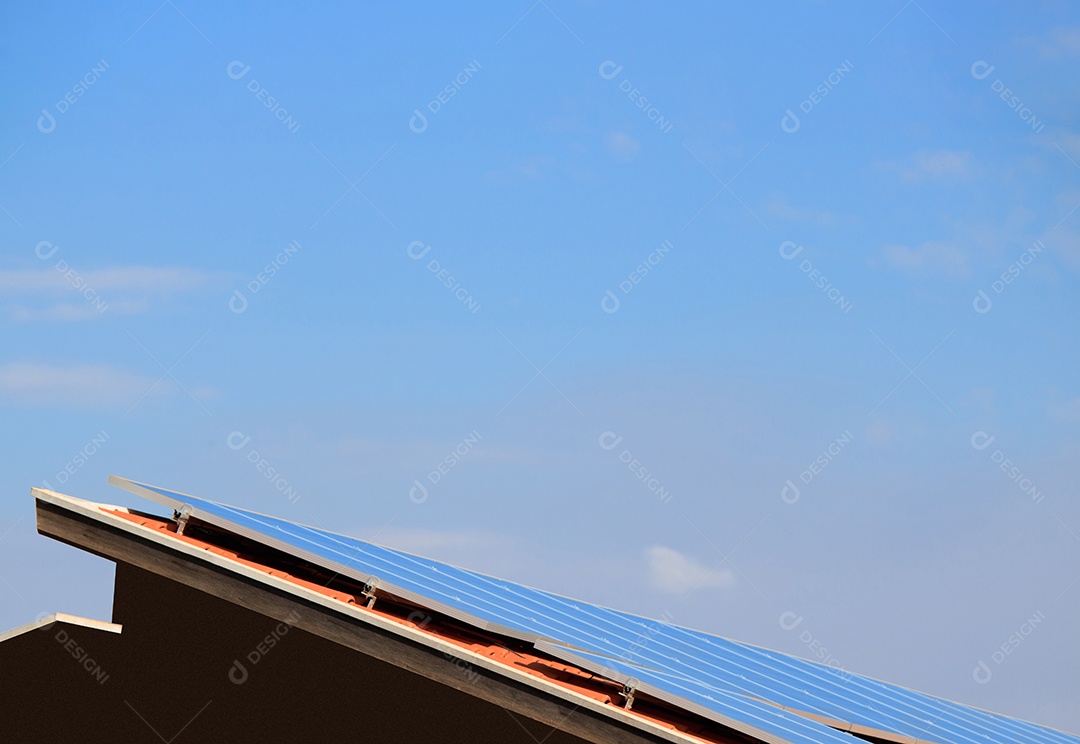 Painéis solares na casa de telhado vermelho em um dia ensolarado e nublado. Instalação de Energia Solar Fotovoltaica.