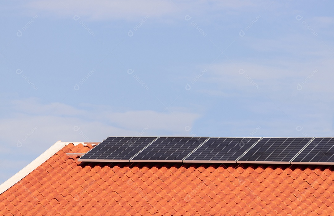 Painéis solares na casa de telhado vermelho em um dia ensolarado e nublado. Instalação de Energia Solar Fotovoltaica.