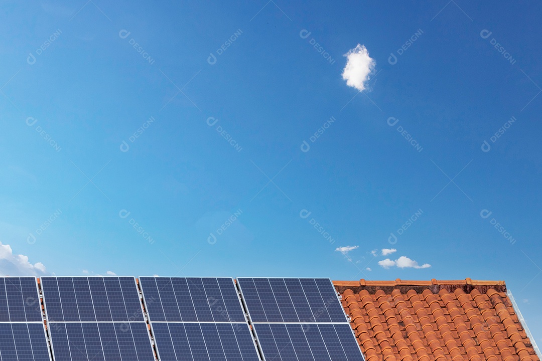 Painéis solares na casa de telhado vermelho em um dia ensolarado e nublado. Instalação de Energia Solar Fotovoltaica.