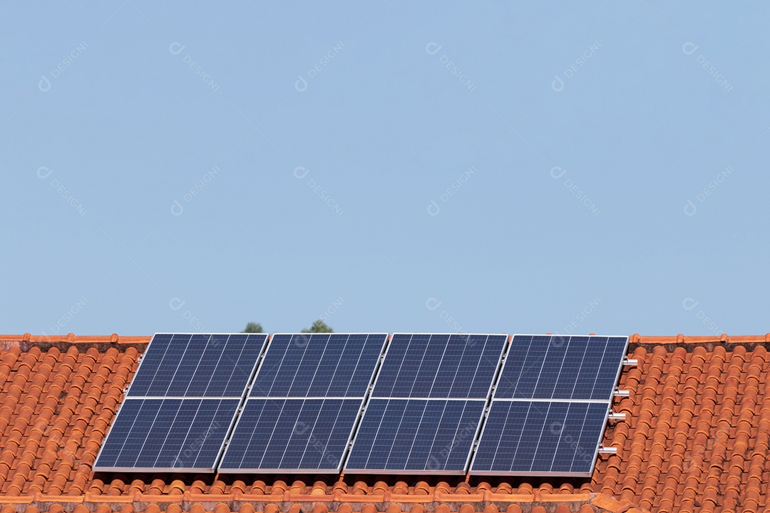 Painéis solares na casa de telhado vermelho em um dia ensolarado e nublado. Instalação de Energia Solar Fotovoltaica.