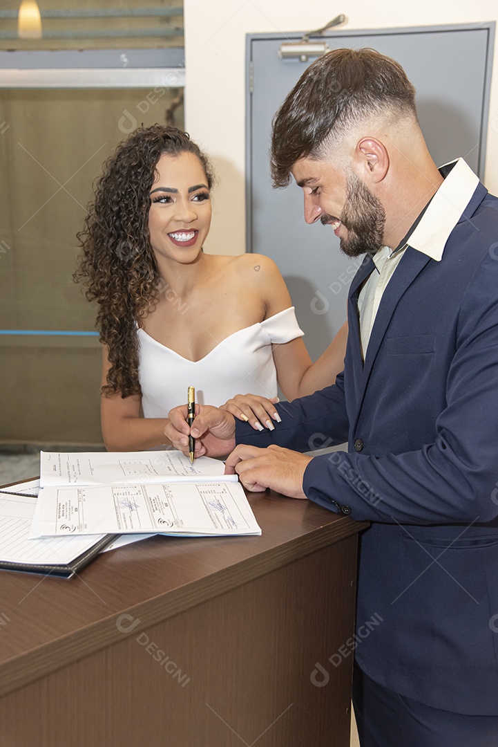 Casal assinando contrato de casamento