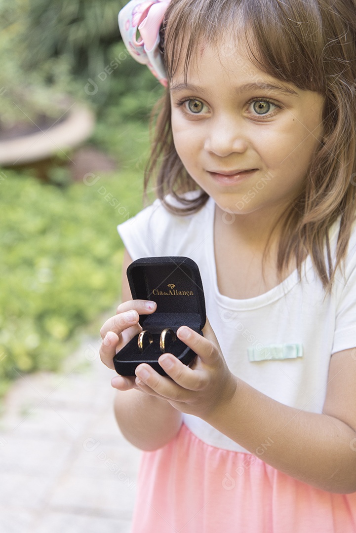 Linda menina jovem porta aliança sobre um casamento