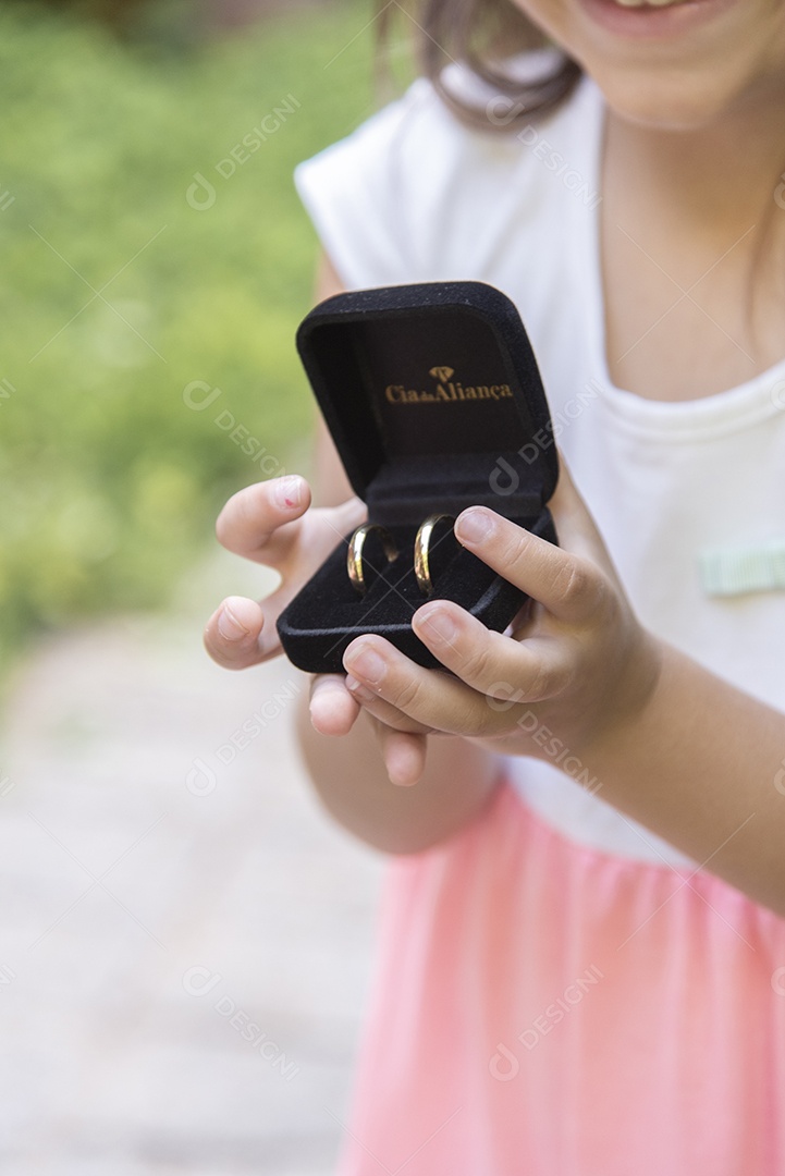 Linda menina jovem porta aliança sobre um casamento