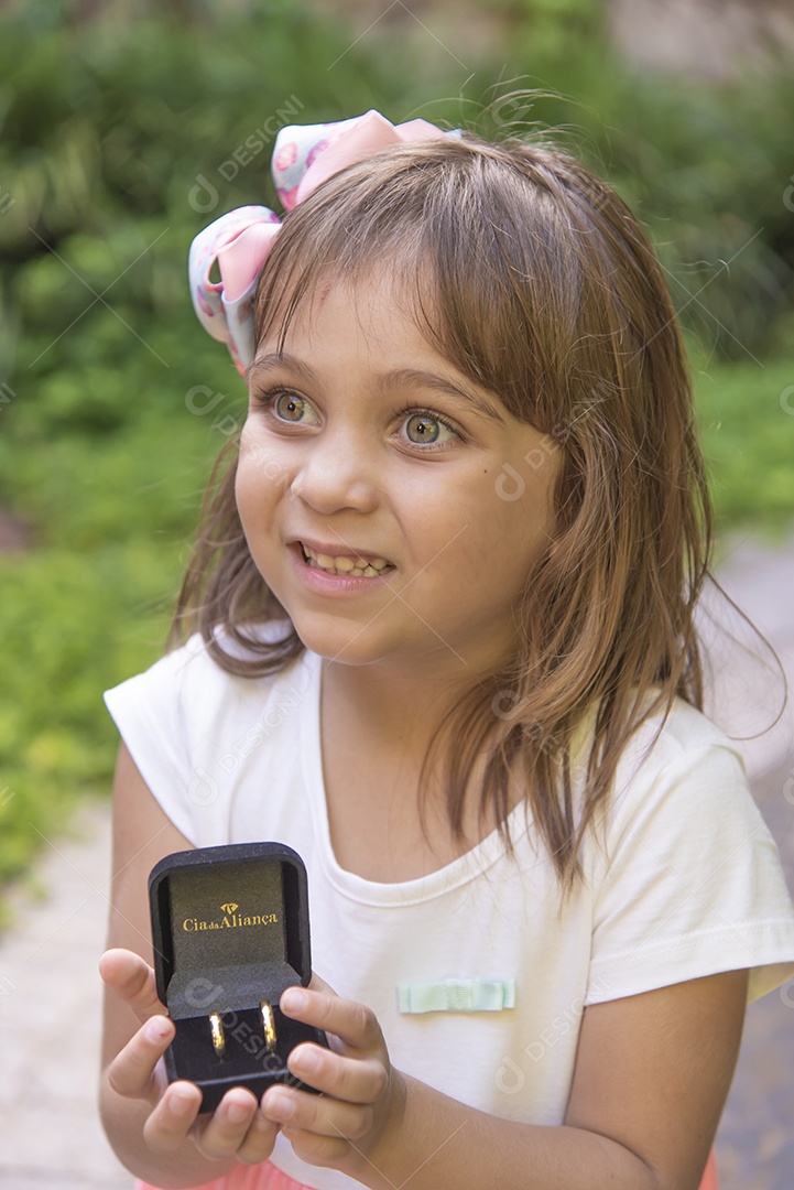 Linda menina jovem porta aliança sobre um casamento