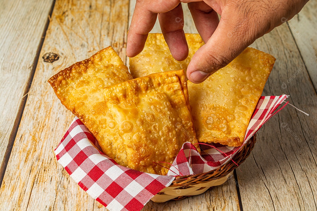 Pastel brasileiro, lanche frito em uma tigela ou recipiente, sobre mesa de madeira