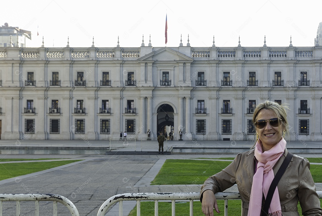 Linda mulher turista sendo fotografada sobre fundo Palácio de La Moneda