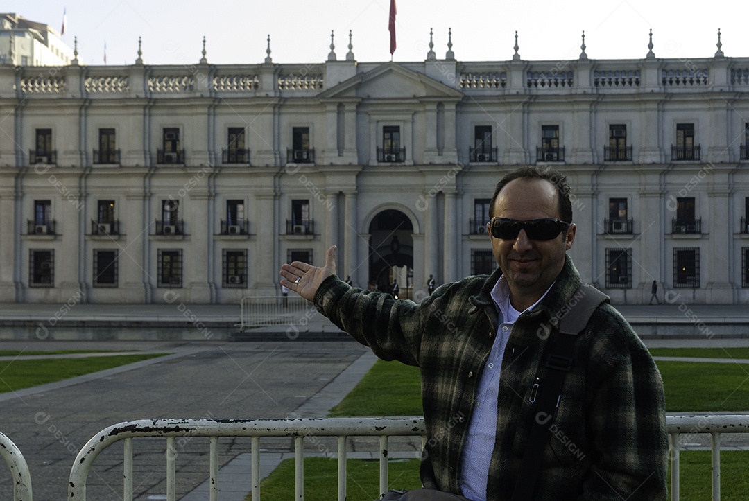 Homem turista sendo fotografada sobre fundo Palácio de La Moneda
