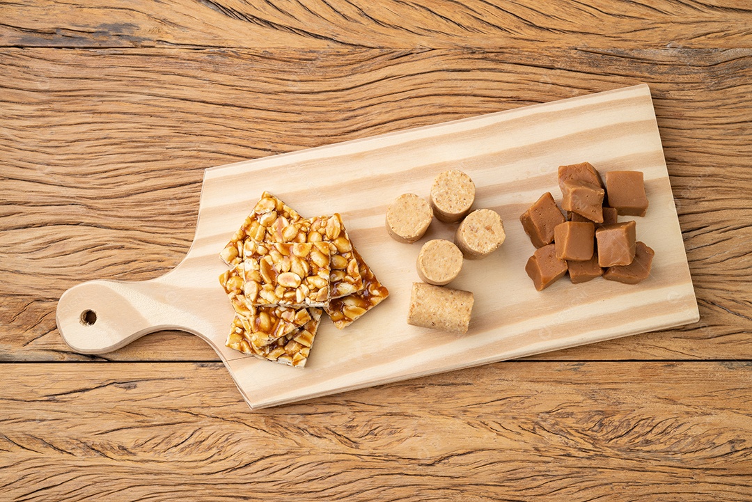 Typical Brazilian sweets on a wooden board. Dulce de leche or dulce de leche, pe de moleque and pacoca.