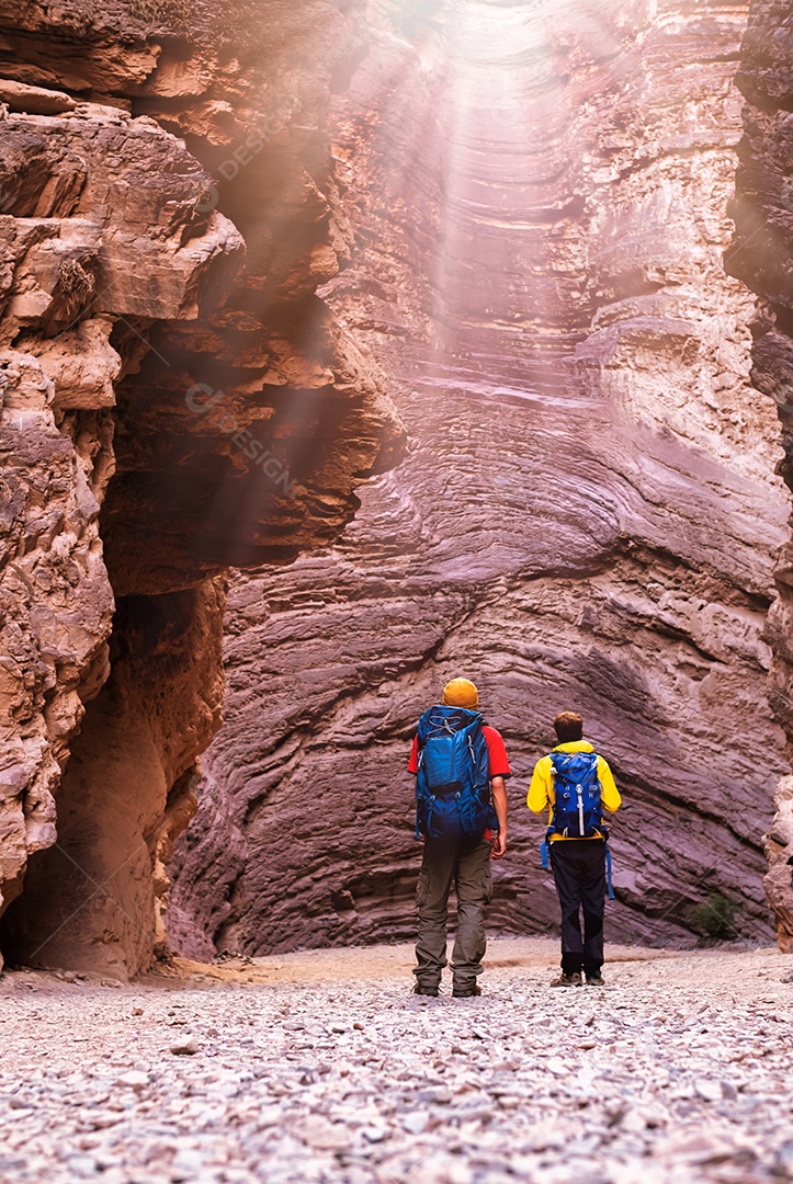 Dois jovens mochileiros observando os raios de sol na cavidade do anfiteatro Quebrada das Conchas em Cafayate