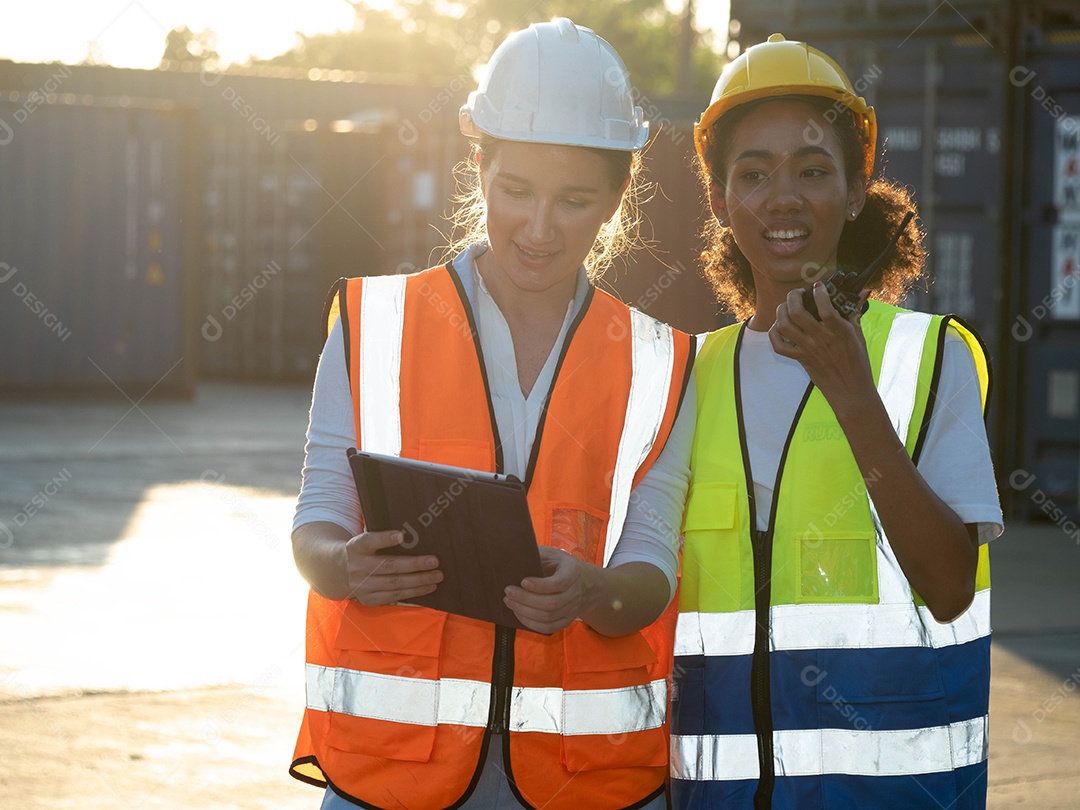 Duas mulheres engenheiras averiguando relatório sobre cargas