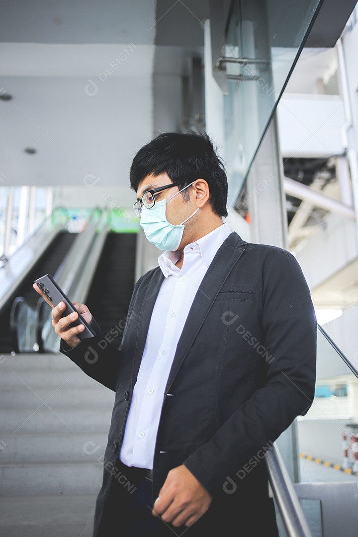 Freelancer masculino asiático usando máscara cirúrgica indo trabalhar de manhã no metrô.