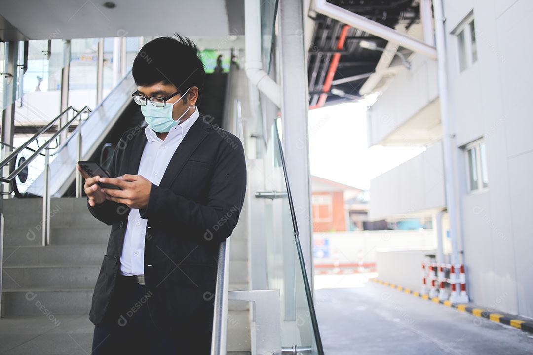 Freelancer masculino asiático usando máscara cirúrgica indo trabalhar de manhã no metrô.