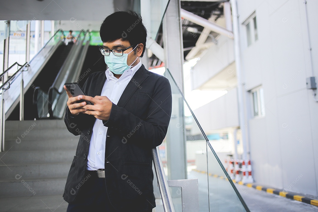 Freelancer masculino asiático usando máscara cirúrgica indo trabalhar de manhã no metrô.