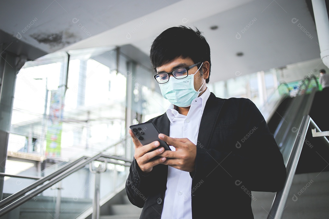 Freelancer masculino asiático usando máscara cirúrgica indo trabalhar de manhã no metrô.