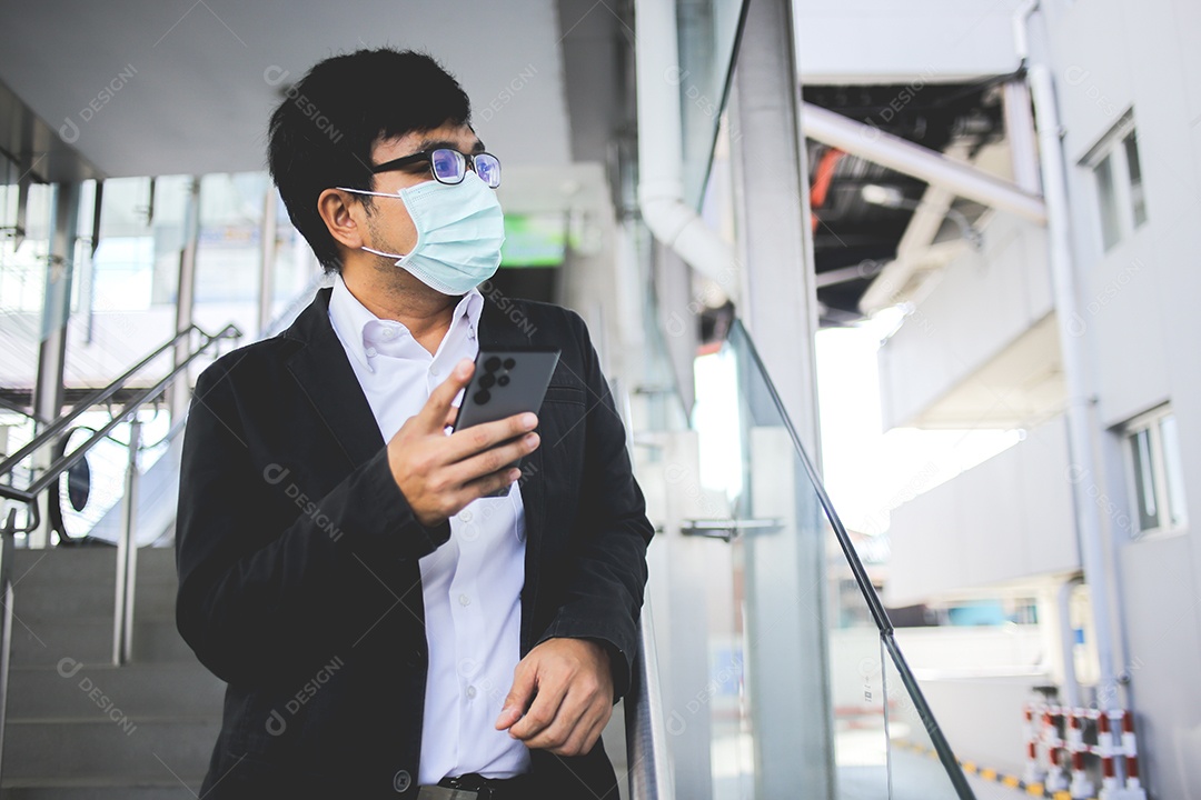 Freelancer masculino asiático usando máscara cirúrgica indo trabalhar de manhã no metrô.