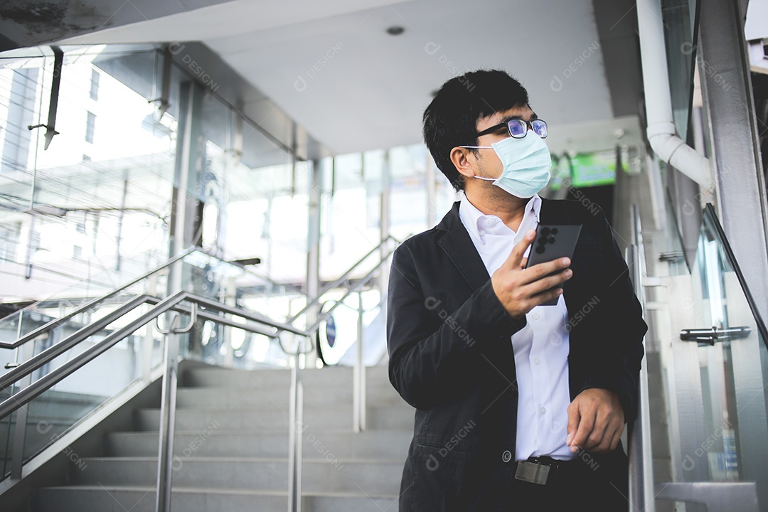Freelancer masculino asiático usando máscara cirúrgica indo trabalhar de manhã no metrô.