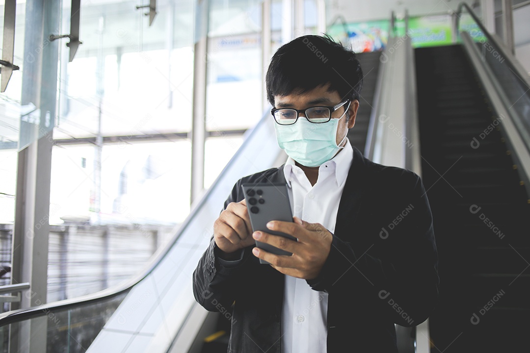 Freelancer masculino asiático usando máscara cirúrgica indo trabalhar de manhã no metrô