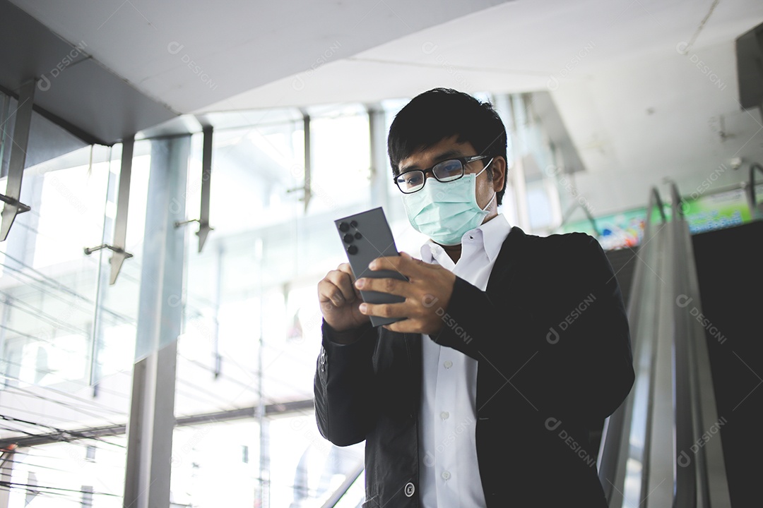 Freelancer masculino asiático usando máscara cirúrgica indo trabalhar de manhã no metrô
