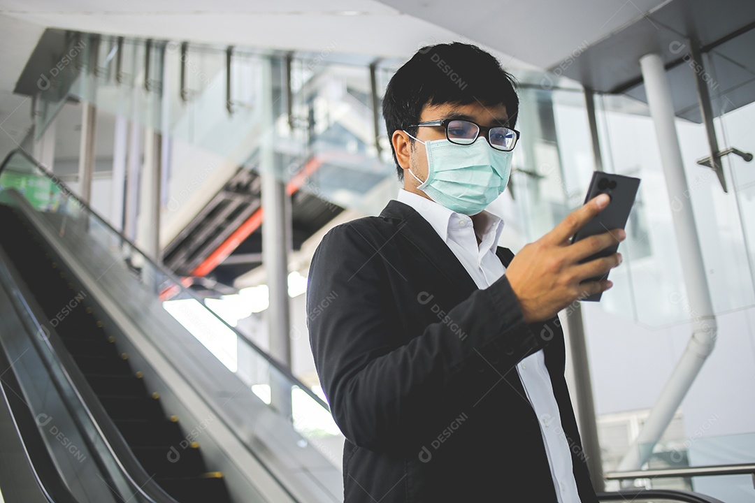 Freelancer masculino asiático usando máscara cirúrgica indo trabalhar de manhã no metrô