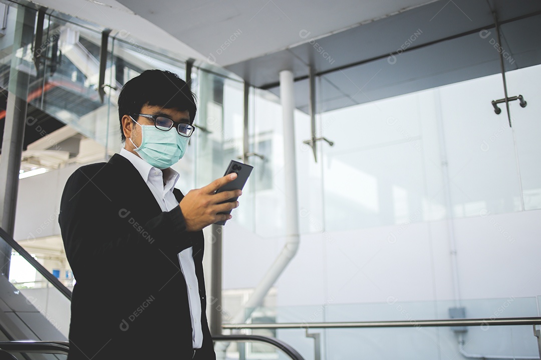Freelancer masculino asiático usando máscara cirúrgica indo trabalhar de manhã no metrô