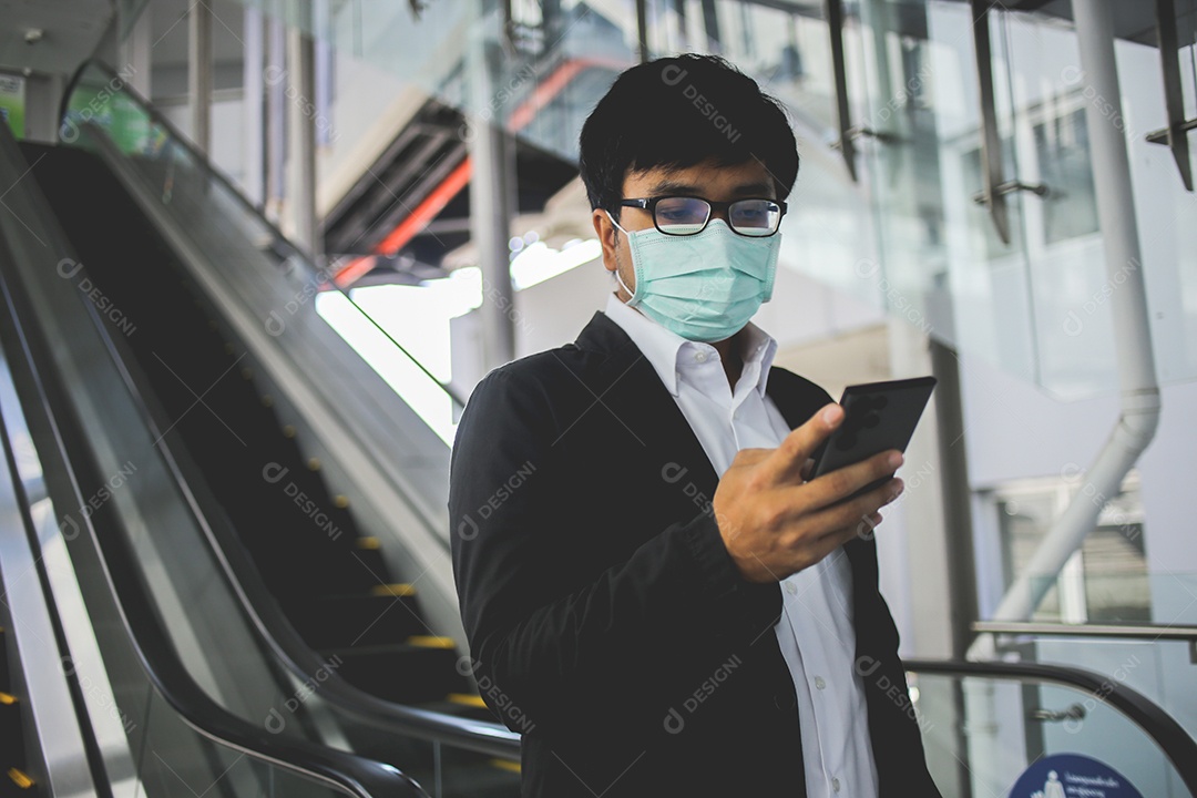 Freelancer masculino asiático usando máscara cirúrgica indo trabalhar de manhã no metrô