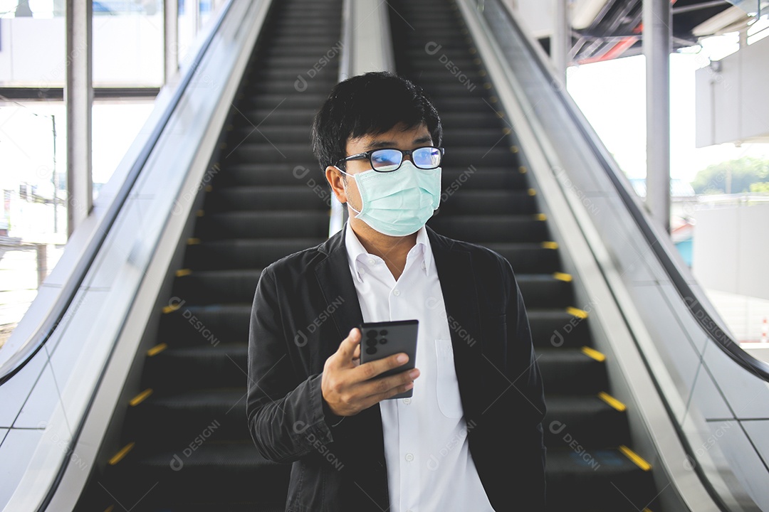 Freelancer masculino asiático usando máscara cirúrgica indo trabalhar de manhã no metrô