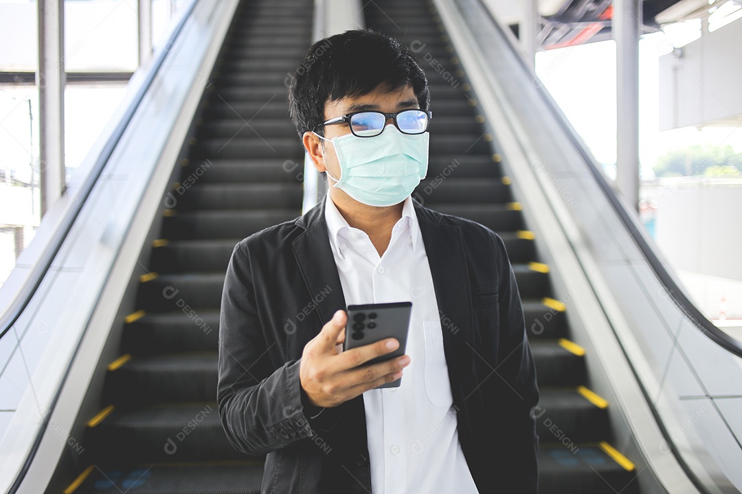 Freelancer masculino asiático usando máscara cirúrgica indo trabalhar de manhã no metrô