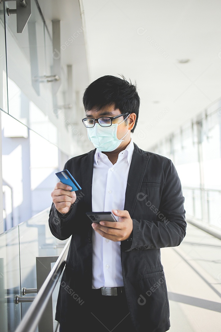 Homem de negócios asiáticos em óculos e usando máscara cirúrgica pagando