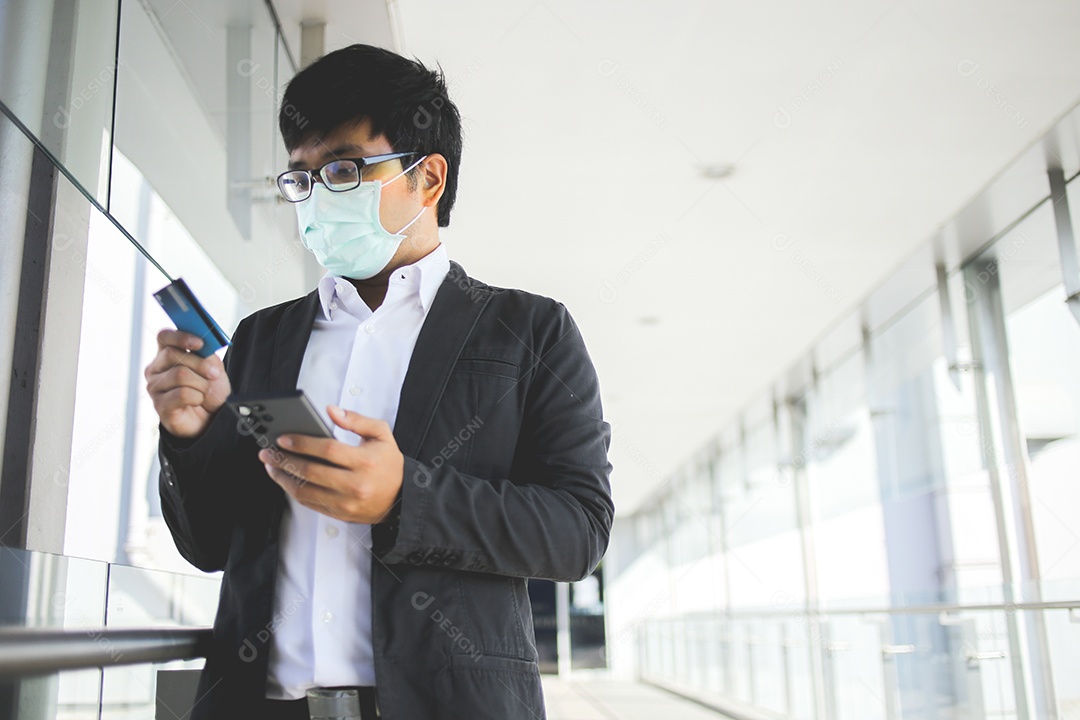 Homem de negócios asiáticos em óculos e usando máscara cirúrgica pagando