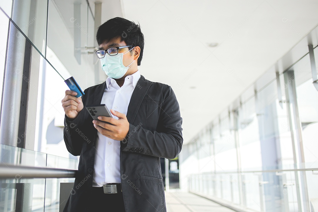 Homem de negócios asiáticos em óculos e usando máscara cirúrgica pagando