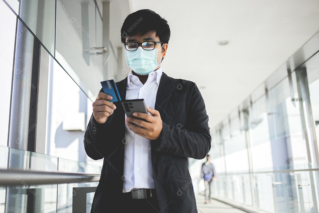 Homem de negócios asiáticos em óculos e usando máscara cirúrgica pagando