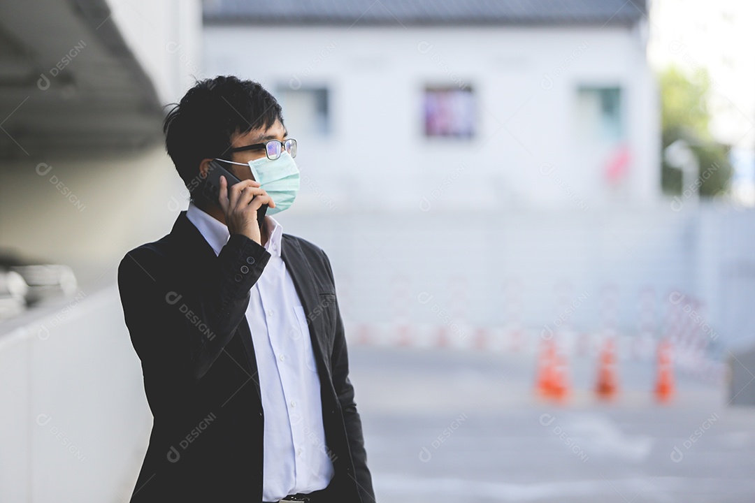 Homem asiático de máscara falando no celular
