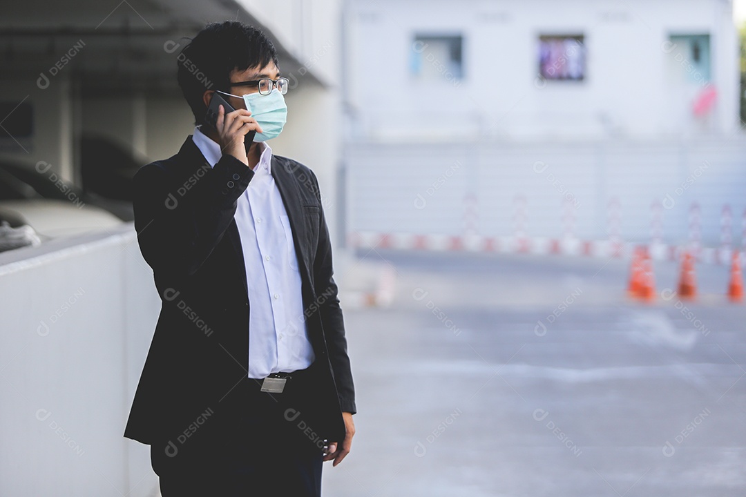 Homem asiático de máscara falando no celular