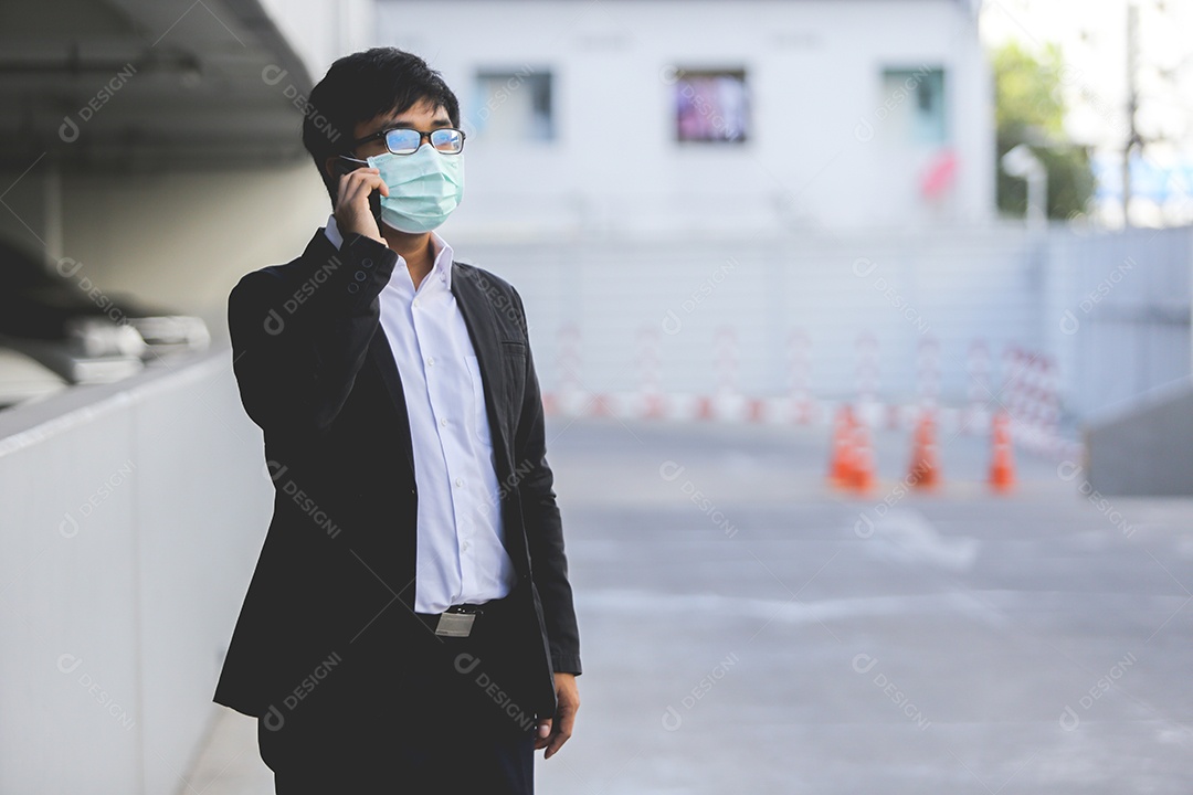 Homem asiático de máscara falando no celular