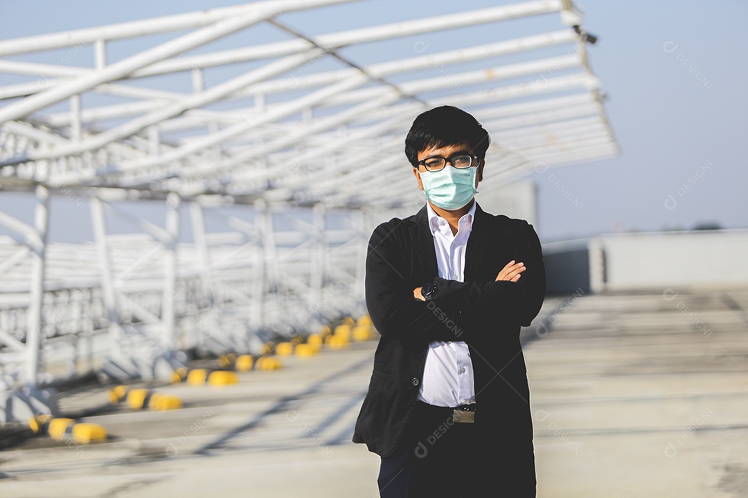 Homem de máscara com braços cruzados