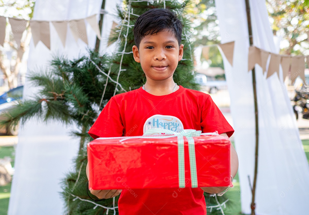 Menino segurando presentes na celebração de Natal. Festival de Natal.